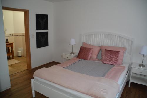 - une chambre dotée d'un lit avec des oreillers roses et gris dans l'établissement Im Maifeld, à Kalt