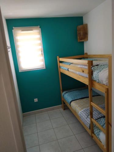 une chambre avec deux lits superposés et une fenêtre dans l'établissement Résidence Village Marin Catalan TORREILLES PLAGE, à Torreilles