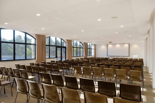 an empty lecture hall with chairs and a whiteboard at SDivine Fatima Hotel, Congress & Spirituality in Fátima