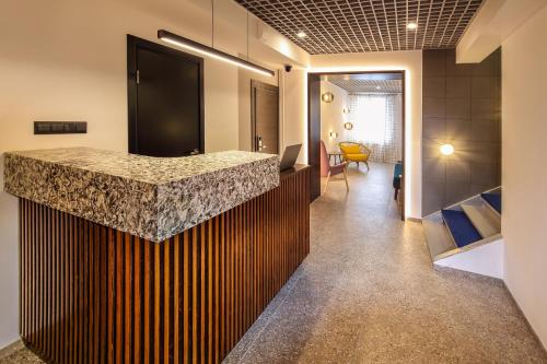eine Küche mit einer Granitarbeitsplatte an einer Wand in der Unterkunft SV Hotel in Wladiwostok