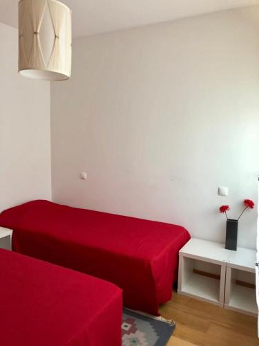 a living room with a red bed and a table at InPorto in Porto