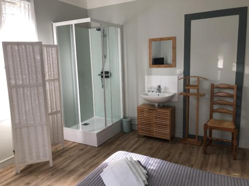 a bathroom with a shower, sink, and tub at Le Commerce in La Haye-du-Puits