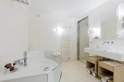 a white bathroom with a glass sink and a mirror at Villa Piedimonte in Ravello