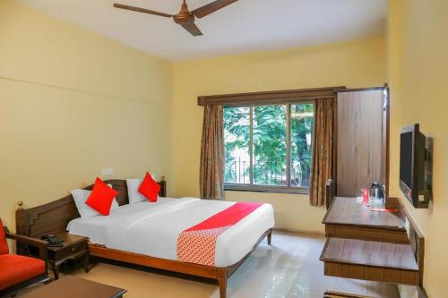 sypialnia z dużym łóżkiem i oknem w obiekcie Hotel Nandanvan Annexe w mieście Pune