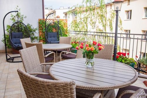 a table with a vase of flowers on a patio at Hotel Hubertus Rzeszów in Rzeszów