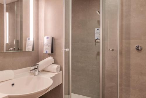 a bathroom with a sink and a shower at Kyriad Montpellier Ouest St Jean de Védas - A709 in Saint-Jean-de-Védas