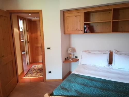 een slaapkamer met een bed en een deur naar een gang bij CASA BRENZ in Madonna di Campiglio