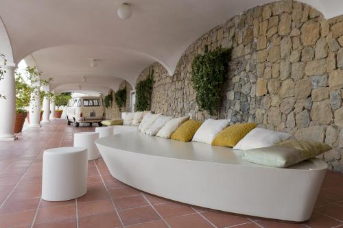 a white couch in a room with a stone wall at Villa Piedimonte in Ravello
