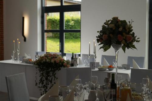 a table with white tables with flowers and candles at Ośrodek Turystyczny Warzenko in Warzenko