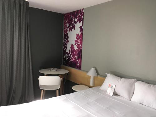 Habitación de hotel con cama y mesa en ibis Laon, en Laon