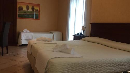 a hotel room with two beds and a window at Hotel Paradiso Delle Madonie in Castelbuono