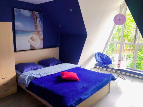 Un dormitorio con una cama azul con una almohada roja. en Green Villa Tsaghveri, en Tsaghveri