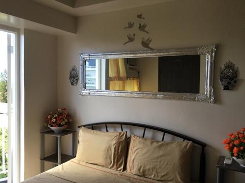 - un miroir au-dessus d'un lit dans une chambre dans l'établissement Condo with Free Swimming Pool & Viewing Deck, à Tagaytay