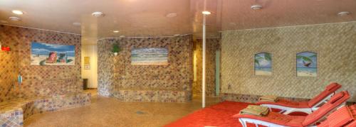 a room with two red chairs and a shower at Hotel Kreuzer in Wedel