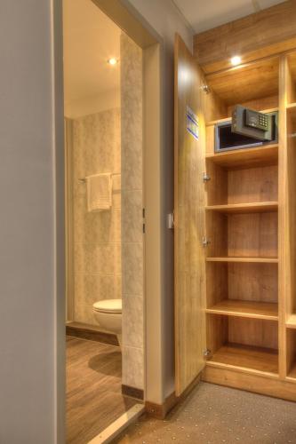 a bathroom with a toilet and a door to a room at Hotel Kreuzer in Wedel