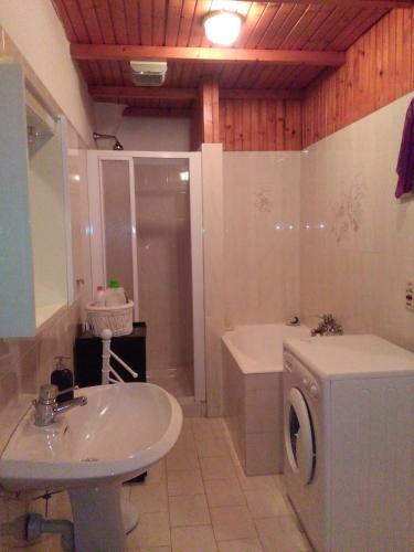ein Badezimmer mit einem Waschbecken und einer Waschmaschine in der Unterkunft Casa Margherita in Santo Stefano al Mare