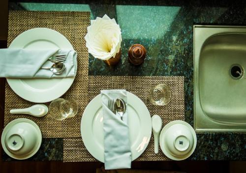 a table with plates and utensils and a sink at Hotel Shwe Yee in Yangon