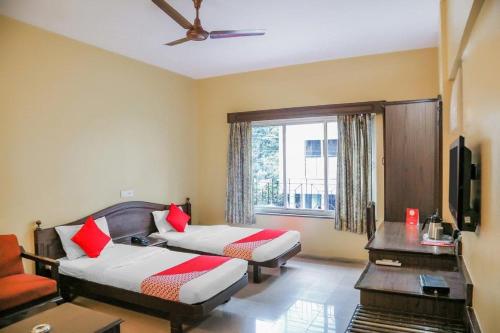 Habitación de hotel con 2 camas y ventana en Hotel Nandanvan Annexe en Pune