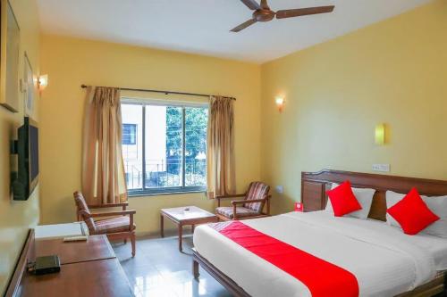 a bedroom with a bed and a desk and a window at Hotel Nandanvan Annexe in Pune