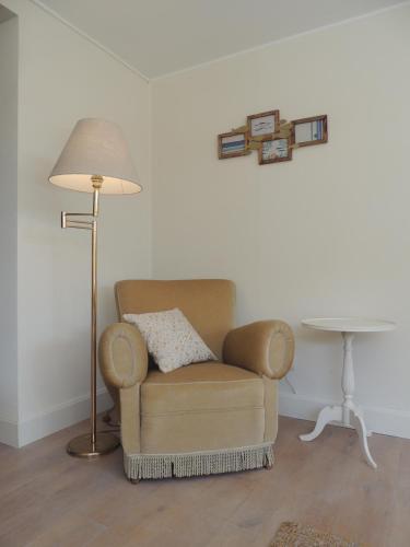 a chair in a room with a lamp and a table at Bed & Breakfast Het Zilte Zand - luxe ontbijt - gratis parking - Westende Middelkerke in Middelkerke