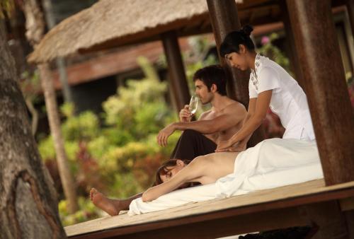a woman getting a massage from a man on a bed at The Seminyak Beach Resort & Spa in Seminyak