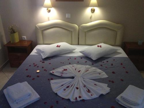 a large bed with a flower decoration on it at Land of Gods in Gythio