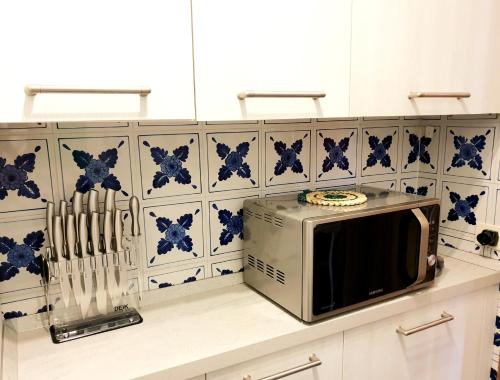 a microwave on a counter with blue and white tiles at Supermountainski Cortina in Cortina dʼAmpezzo