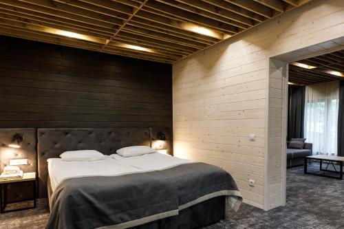 a large bed in a room with wooden walls at Voevodyno Resort in Tur'ya Pasika