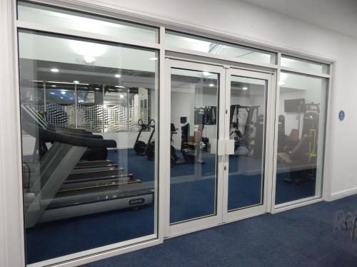 a gym with glass doors and a treadmill at Flamingo Land - Maple Grove MG32 in Kirby Misperton