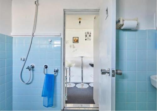 ein Bad mit einer Dusche und blauen Fliesen in der Unterkunft 2BR 5beds Shibuya Shinjuku Harajuku 10min wifi in Tokio