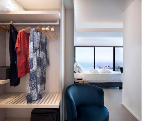 una camera con letto e sedia blu di The View Luxury Apartments Taormina a Taormina