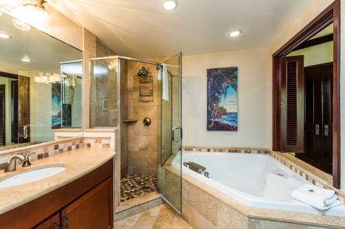 a bathroom with a tub and a shower at Waipouli Beach Resort VIP Ocean Front Penthouse Villa! AC Pool in Kapaa