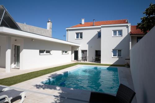 a swimming pool in the backyard of a house at The Spot Hostel Ofir in Esposende