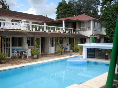 una gran piscina frente a una casa en Hotel Restaurant Hellenique Appartements en Kigali