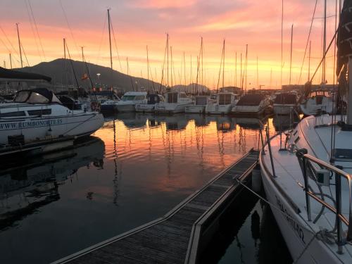 eine Gruppe von Booten, die bei Sonnenuntergang in einem Yachthafen angedockt sind in der Unterkunft Yate de lujo en Getxo in Getxo