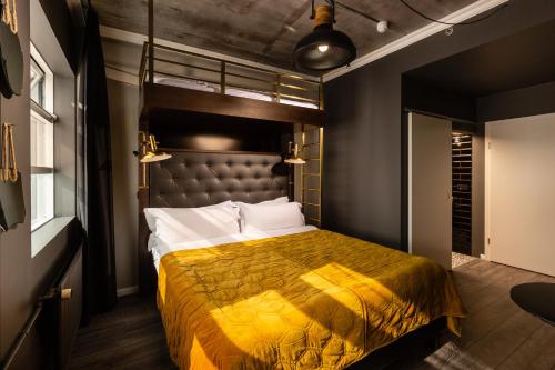 ein Schlafzimmer mit einem Bett mit gelber Tagesdecke in der Unterkunft R13 - A Townhouse Hotel in Reykjavík
