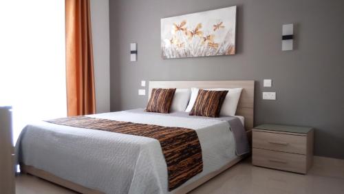 a bedroom with a bed and a painting on the wall at Bright Stylish Apartment in Victoria