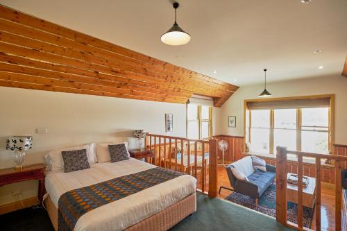 a bedroom with a bed and a chair at Bushman's at Strahan in Strahan