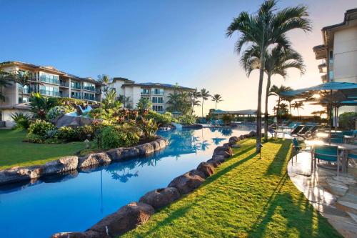 un complejo con piscina con palmeras y un complejo en Waipouli Beach Resort Penthouse Beautiful Oceanview Aloha! AC Pool, en Kapaa