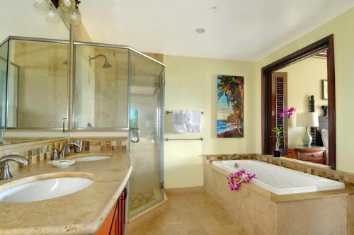 y baño con bañera, lavamanos y ducha. en Waipouli Beach Resort Exquisite Luxury VIP Oceanfront Condo! AC Pool, en Kapaa