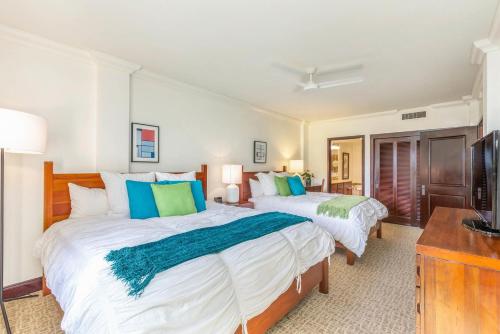 a bedroom with two beds and a television at Waipouli Beach Resort Extra Large Unit! Luxurious Decor! Sleeps up to 8* in Kapaa