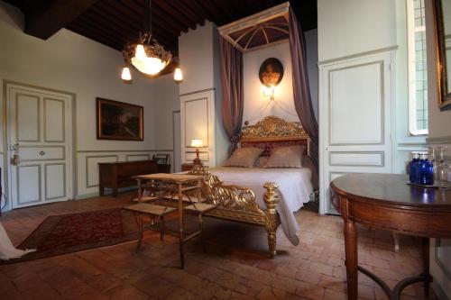 a bedroom with a king sized bed and a table at Château de Varennes in Varennes-lès-Mâcon