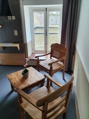a living room with a wooden table and chairs at Canalview Hotel Ter Reien in Bruges