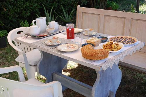 una mesa de picnic con comida y bebidas. en La Ripa Bed and Breakfast, en Blera