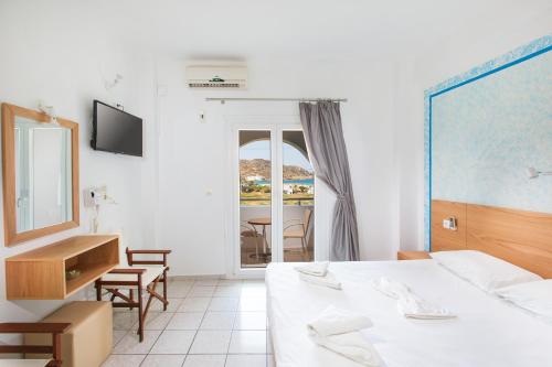 una camera con letto, scrivania e specchio di Marcos Beach a Mylopotas