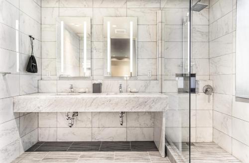 a white bathroom with a sink and a shower at The Gallivant Times Square in New York