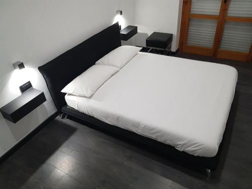 a bedroom with a white bed with two lamps at Cinecittà Luxury GUEST HOUSE in Rome