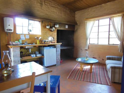 cocina y sala de estar con sofá y mesa en Simonskloof Mountain Retreat, en Montagu