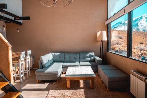 a living room with a couch and a table at Casas De Montaña Las Leñas Los Molles in Los Molles