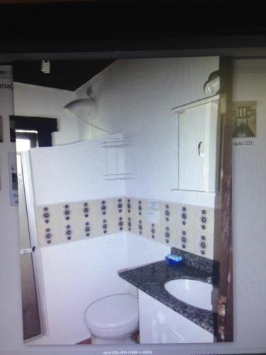 a bathroom with a toilet and a sink at apartamento a 20 metros do mar bombinhas in Bombinhas
